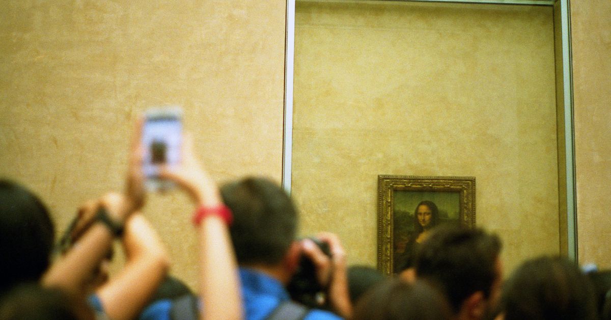 Turistas y visitantes toman fotografía a Cuadro de Mona Lisa en Museo de Louvre