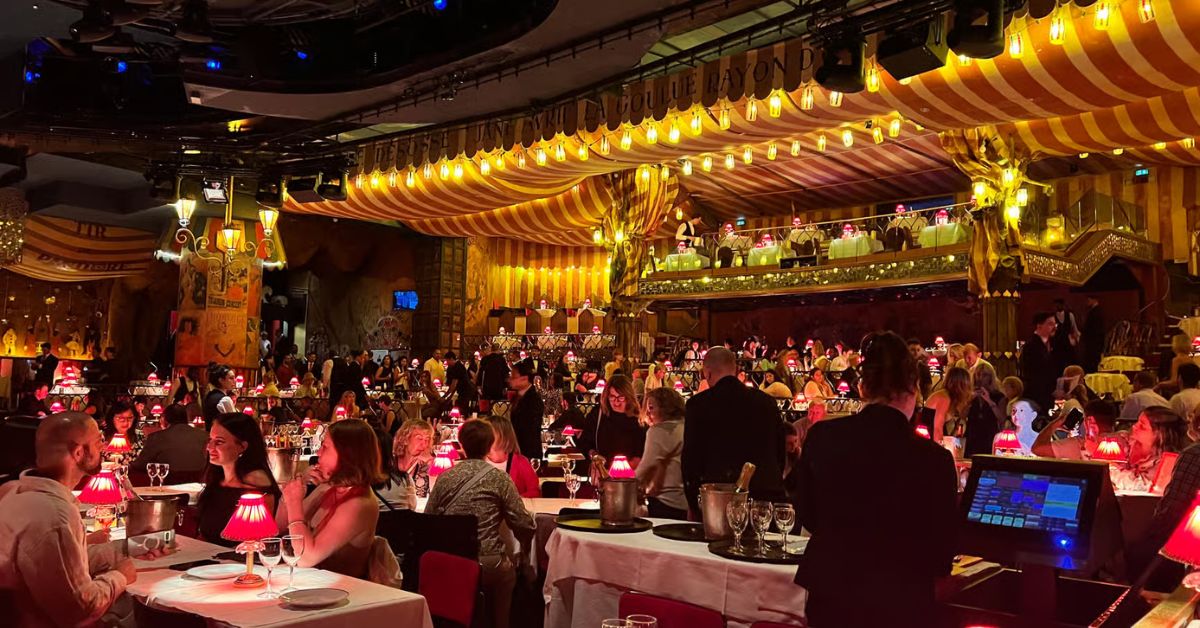 Turistas disfrutan en Cabaret de Moulin Rouge, París