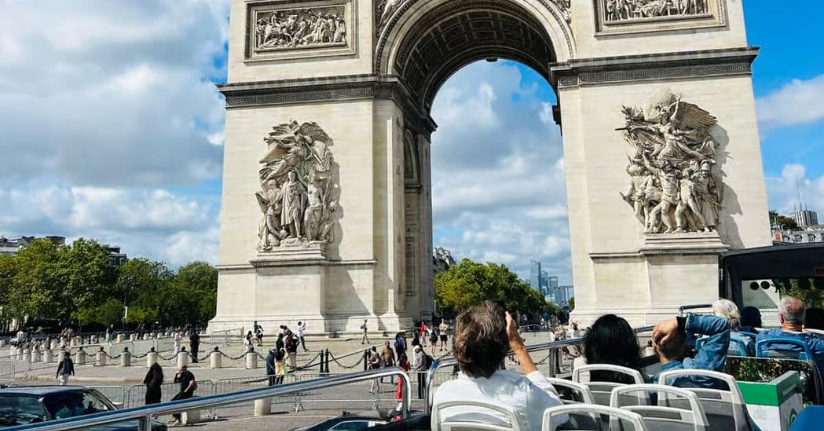 Bus turístico recorre cerca de Arco del triunfo en París, Francia