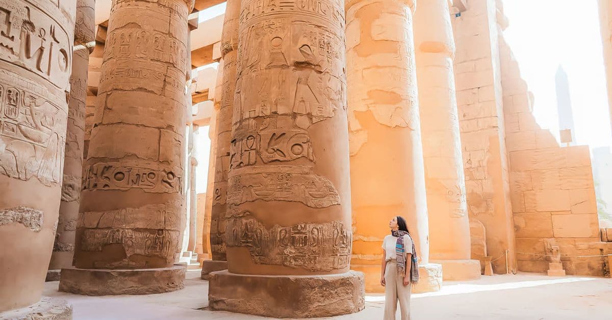 Mujer observa los grandes muros del Templo de Luxor