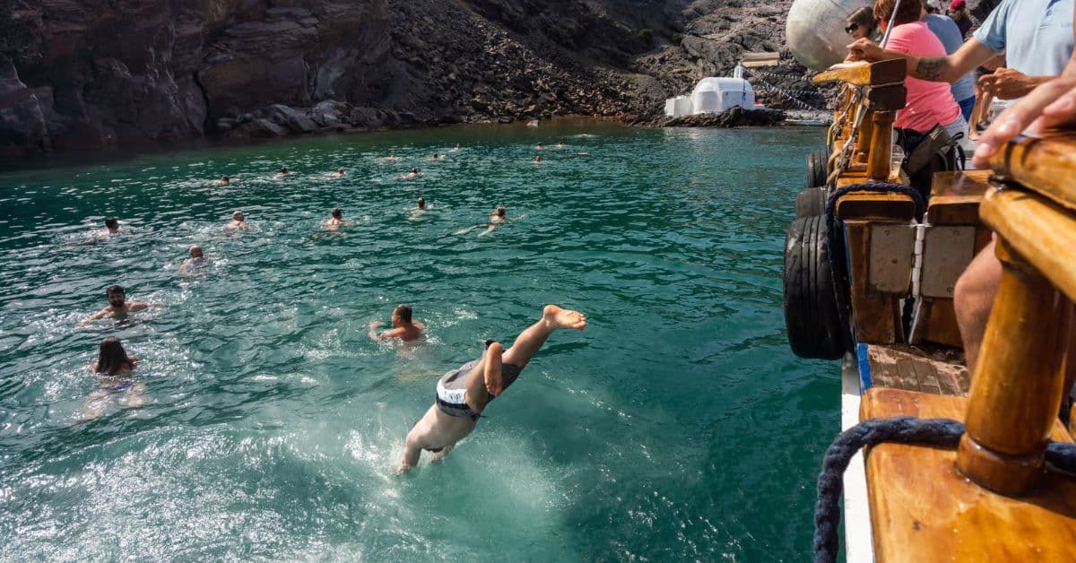 Turistas hacen parada para nadar en la isla Thirassia, Santorini, Grecia