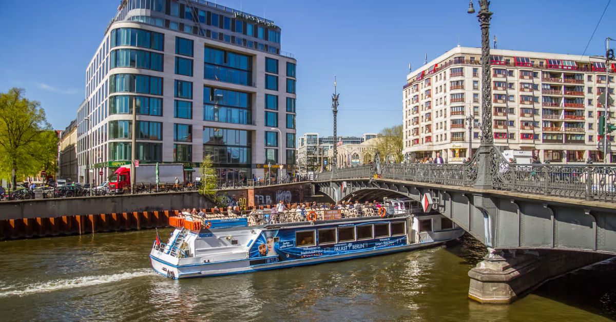Crucero atraviesa puente sobre el río spree con vista a Distrito gubernamental