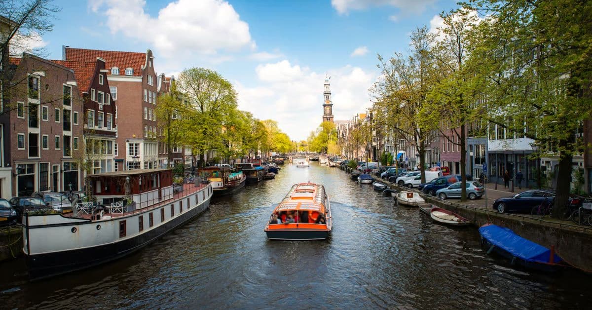 Embarcación con turistas viajan por río en Ámsterdam, Países Bajos