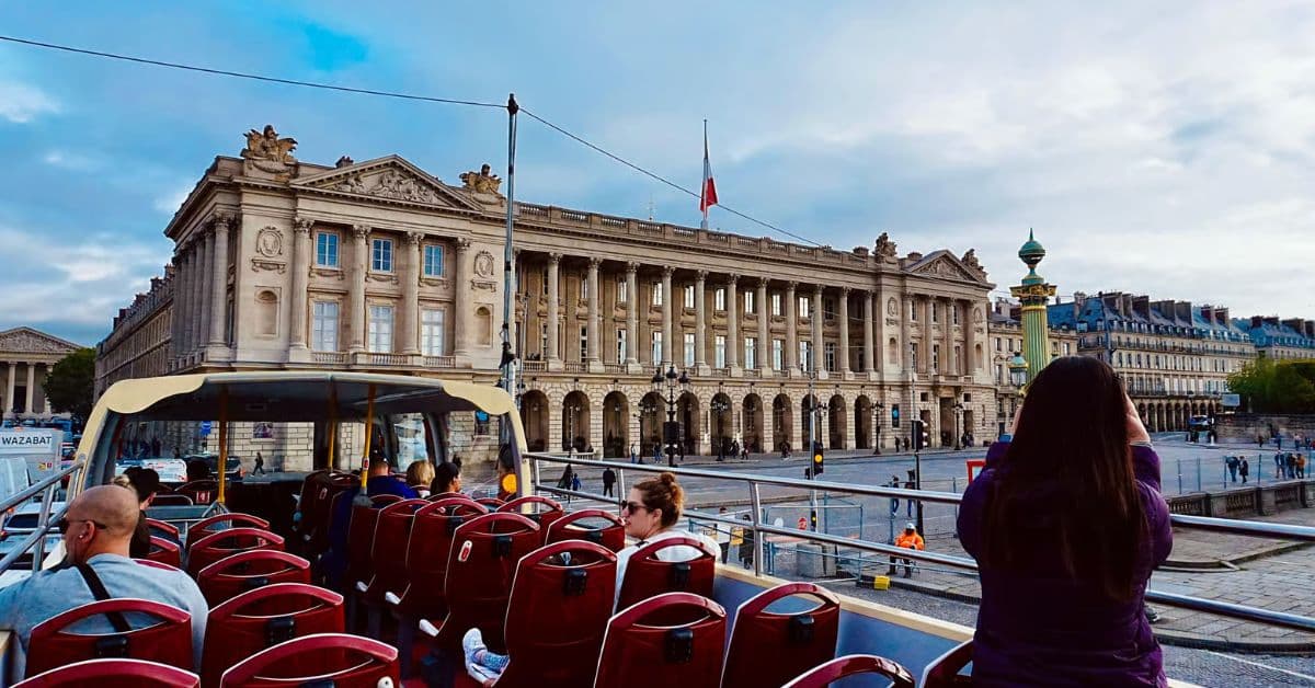Turistas a bordo de autobús turístico Big Bus en recorrido por París, Francia