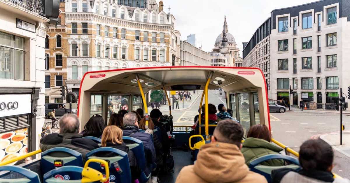 Turistas disfrutan tour sobre autobús turístico en Londres, Reino Unido